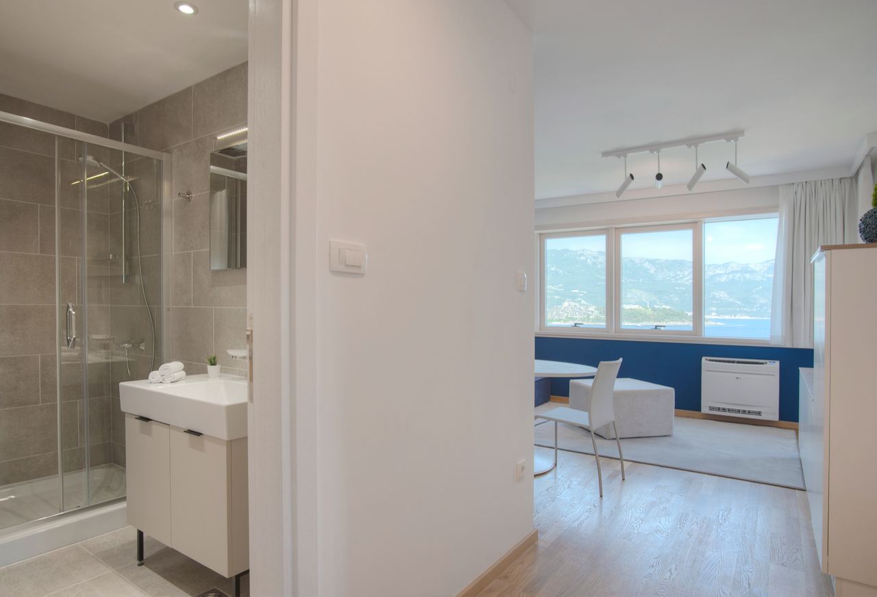 Купить трехкомнатную квартиру в Будве: вид из коридора на гостиную и туалетную комнату